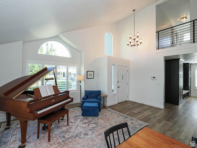 foyer entrance with a chandelier, wood finished floors, high vaulted ceiling, and baseboards