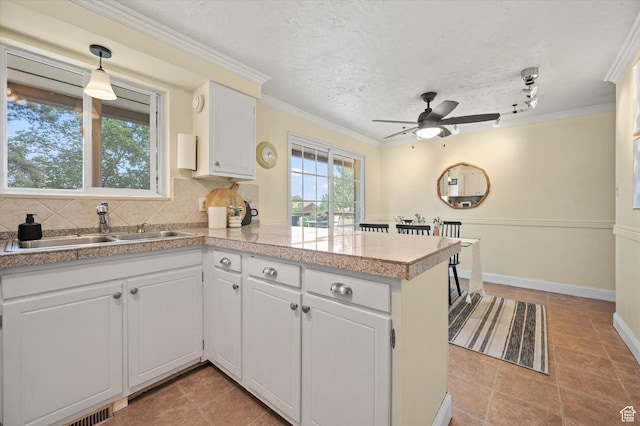 2068 S 200 E, Bountiful, UT 84010 - kitchen with a peninsula, a sink, white cabinets, ceiling fan, and crown molding