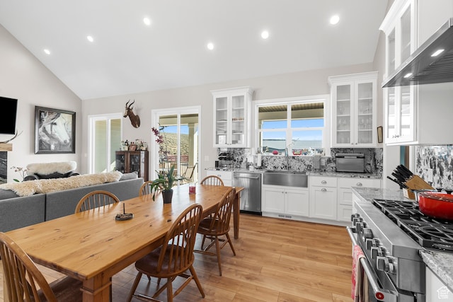 7664 Whileaway E, Park City, UT 84098 - kitchen featuring stainless steel appliances, wall chimney exhaust hood, white cabinets, backsplash, and high vaulted ceiling
