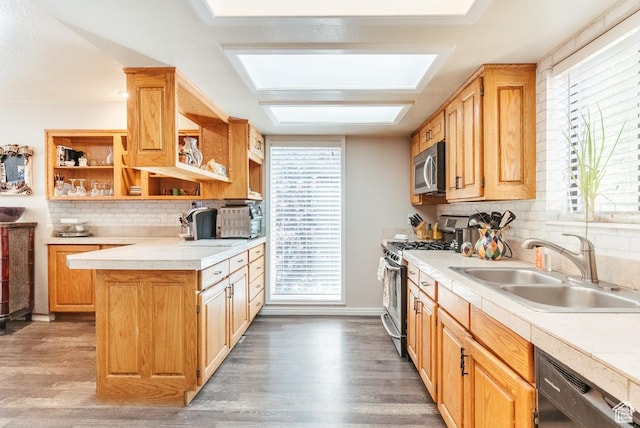 kitchen featuring appliances with stainless steel finishes, a sink, open shelves, light countertops, and backsplash