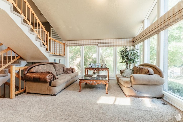 carpeted living room featuring stairs and vaulted ceiling
