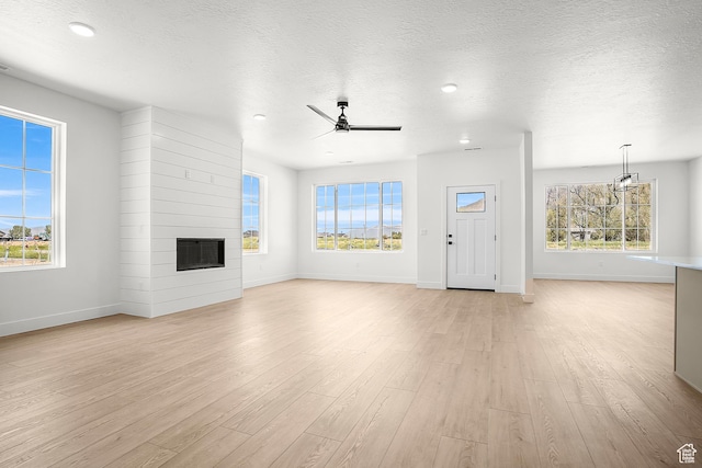 1631 W Century Ln Unit A, Mapleton, UT 84664 - unfurnished living room with baseboards, a large fireplace, light wood finished floors, a textured ceiling, and recessed lighting