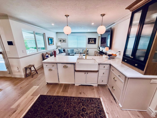 1367 N Brookhurst Cir, Centerville, UT 84014 - kitchen with a sink, light wood finished floors, a peninsula, decorative light fixtures, and a textured ceiling