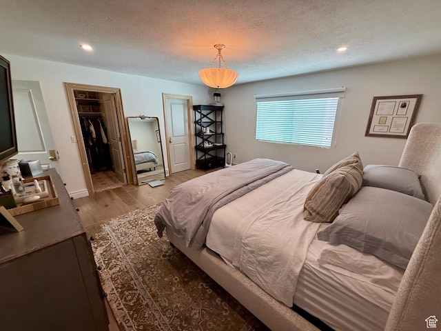 1367 N Brookhurst Cir, Centerville, UT 84014 - bedroom with wood finished floors, a textured ceiling, recessed lighting, and a walk in closet