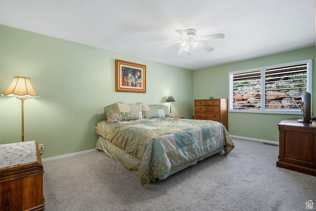 carpeted bedroom featuring baseboards and a ceiling fan