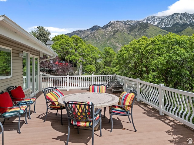 deck featuring outdoor dining area and a mountain view