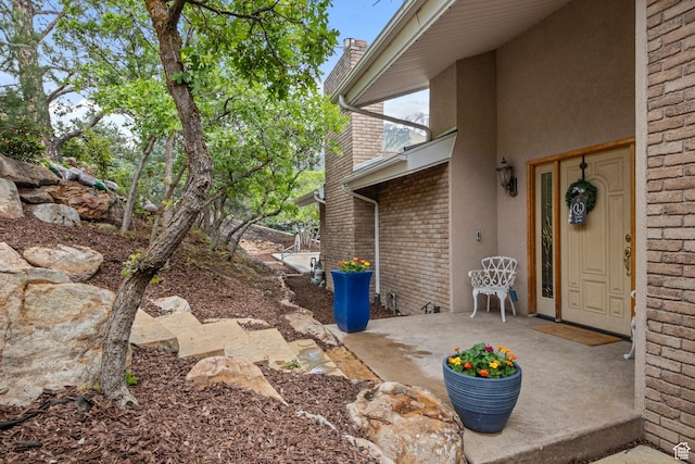 property entrance featuring brick siding and stucco siding