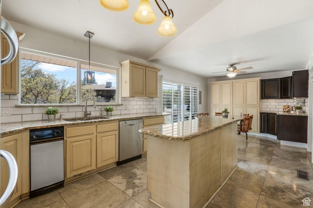 kitchen with stainless steel dishwasher, a sink, decorative backsplash, light brown cabinets, and lofted ceiling