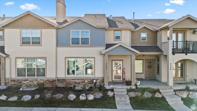 5062 W Valmont Way, Herriman, UT 84096 - townhome / multi-family property featuring a balcony, stucco siding, a chimney, and a shingled roof
