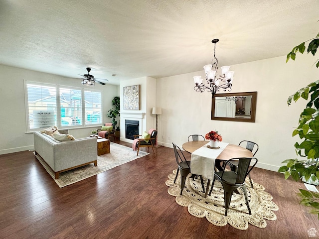5062 W Valmont Way, Herriman, UT 84096 - dining space with a fireplace, dark wood-type flooring, baseboards, a chandelier, and a textured ceiling