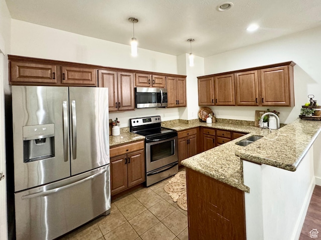 5062 W Valmont Way, Herriman, UT 84096 - kitchen with stainless steel appliances, a sink, a peninsula, light stone counters, and decorative light fixtures