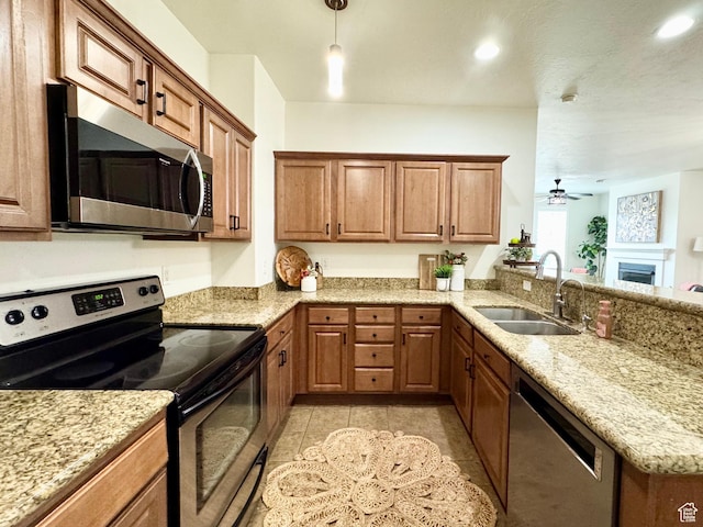 5062 W Valmont Way, Herriman, UT 84096 - kitchen with stainless steel appliances, a sink, a peninsula, brown cabinets, and recessed lighting