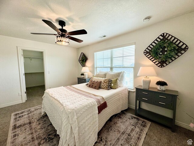 5062 W Valmont Way, Herriman, UT 84096 - bedroom with carpet, ceiling fan, baseboards, a walk in closet, and a textured ceiling
