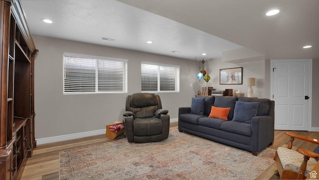 living room with baseboards, wood finished floors, and recessed lighting