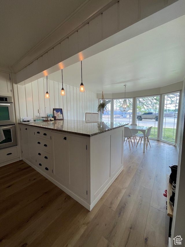 578 S 1500 W, Vernal, UT 84078 - kitchen with stainless steel double oven, light wood-style flooring, white cabinets, and light stone counters