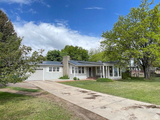 578 S 1500 W, Vernal, UT 84078 - view of front facade with driveway, a front yard, a chimney, an attached garage, and metal roof