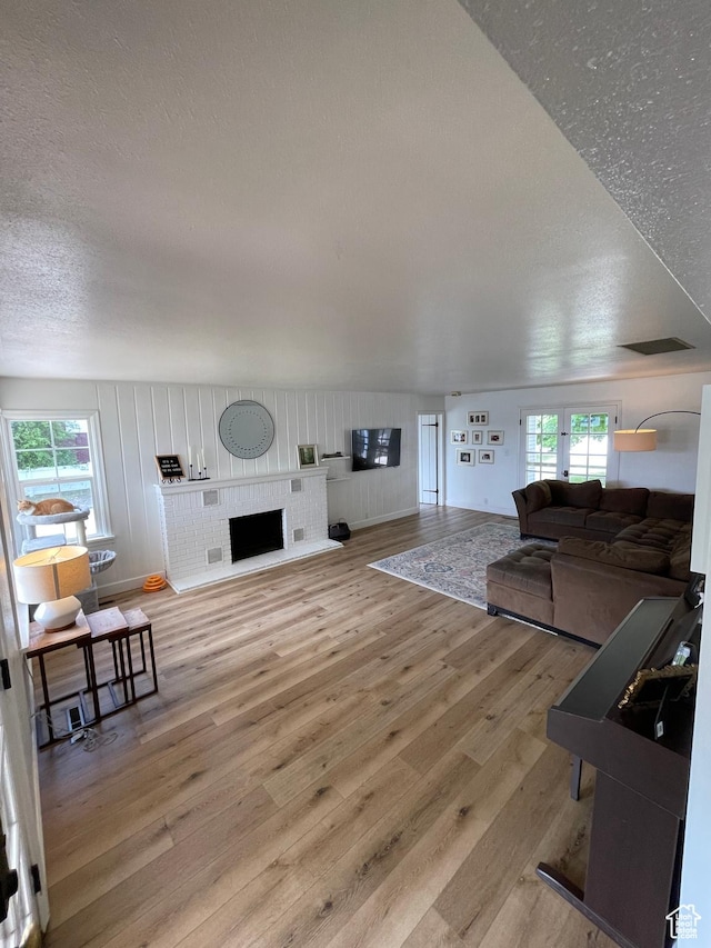 578 S 1500 W, Vernal, UT 84078 - living room featuring light wood-style flooring, a textured ceiling, and a brick fireplace