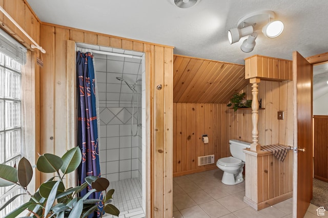 312 E 1st S, Preston, ID 83263 - bathroom featuring wooden walls, a stall shower, toilet, tile patterned flooring, and vaulted ceiling
