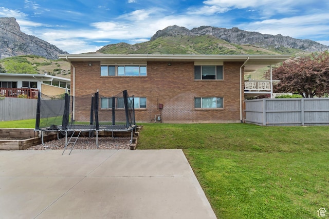 1485 E 1850 N, Provo, UT 84604 - back of house featuring a trampoline, a mountain view, a patio area, and brick siding