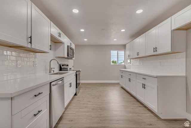 4098 W 5580 S, Salt Lake City, UT 84118 - kitchen featuring appliances with stainless steel finishes, a sink, baseboards, recessed lighting, and light wood-type flooring
