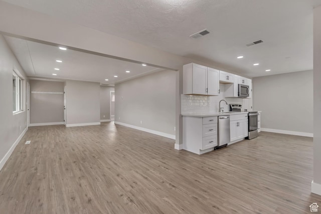 4098 W 5580 S, Salt Lake City, UT 84118 - kitchen with stainless steel appliances, baseboards, light wood-style flooring, light countertops, and decorative backsplash