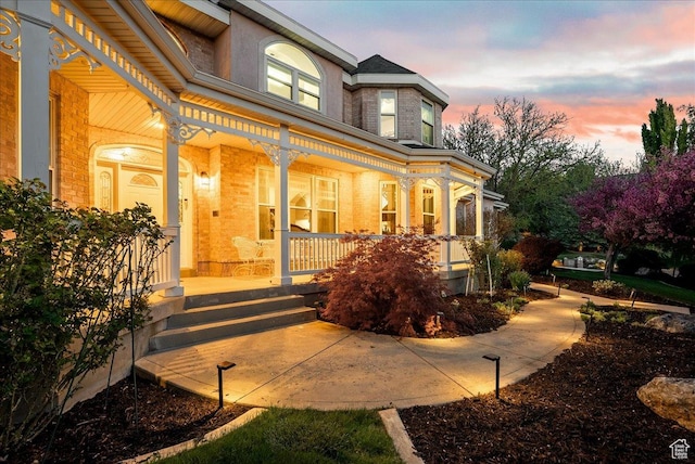 14 N 1025 E, Lindon, UT 84042 - exterior entry at dusk featuring a porch and brick siding