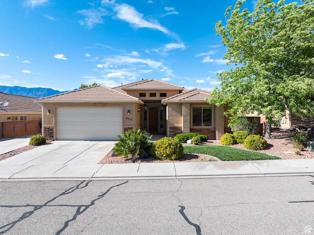 2710 W 410 N, Hurricane, UT 84737 - prairie-style house with stucco siding, a garage, concrete driveway, a tiled roof, and stone siding