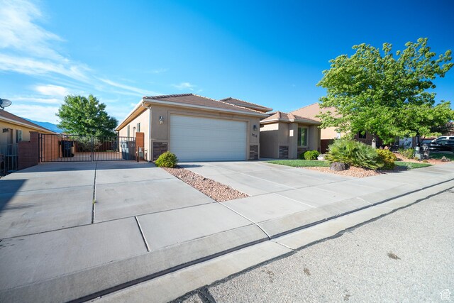 2710 W 410 N, Hurricane, UT 84737 - single story home with a gate, driveway, stone siding, a garage, and a tile roof