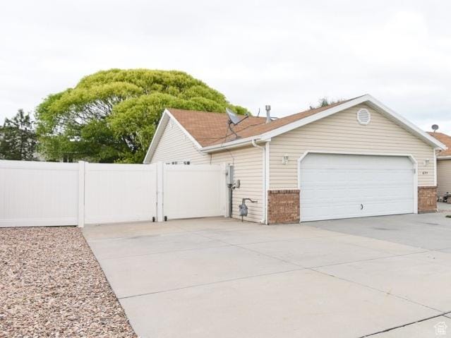 635 E Hunter Way N, Grantsville, UT 84029 - view of side of home with brick siding, driveway, and a garage