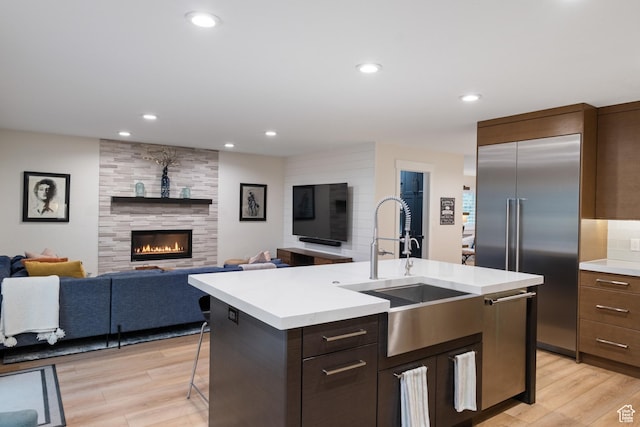 1288 E Foxcrest Ct, Park City, UT 84098 - kitchen with a sink, stainless steel appliances, light countertops, light wood-style flooring, and a kitchen island with sink