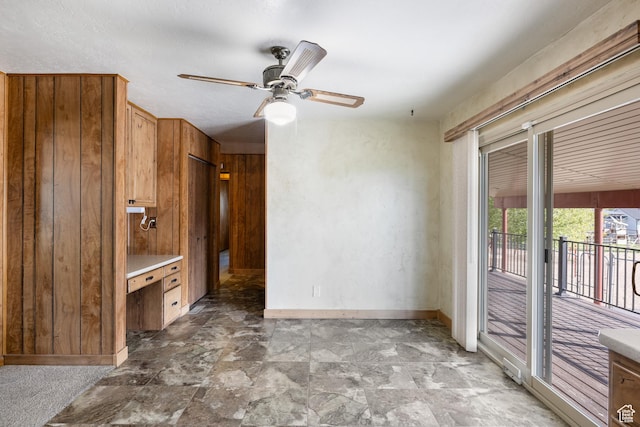 5685 N State Road 32, Peoa, UT 84061 - unfurnished living room featuring baseboards, ceiling fan, wood walls, and light stone finish flooring