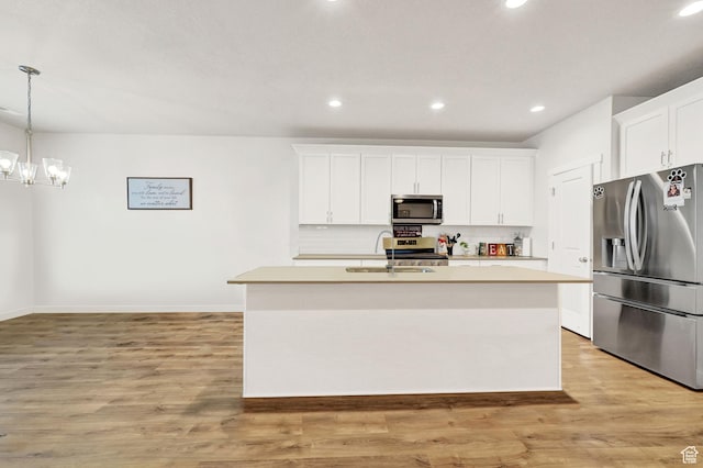 114 N 3830 W, West Point, UT 84015 - kitchen featuring stainless steel appliances, a sink, a kitchen island with sink, tasteful backsplash, and light countertops