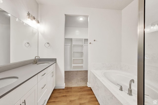 114 N 3830 W, West Point, UT 84015 - bathroom featuring double vanity, a bath, a walk in closet, and wood finished floors