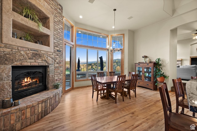 9266 Par Ct, Park City, UT 84098 - dining room featuring a brick fireplace, light wood-type flooring, a chandelier, recessed lighting, and a mountain view