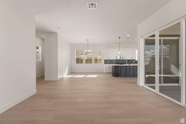 669 Juniper Hill Dr, St George, UT 84790 - unfurnished living room with a chandelier, baseboards, light wood finished floors, and recessed lighting