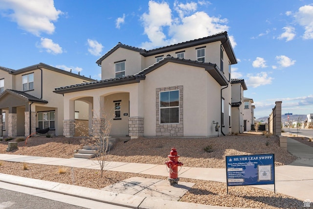 669 Juniper Hill Dr, St George, UT 84790 - mediterranean / spanish house with stucco siding, a porch, a tiled roof, and stone siding