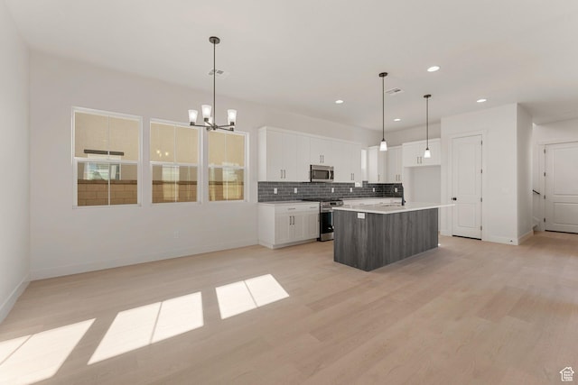 669 Juniper Hill Dr, St George, UT 84790 - kitchen featuring appliances with stainless steel finishes, a chandelier, backsplash, baseboards, and white cabinetry