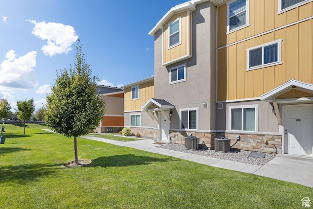 236 E 630 N, Vineyard, UT 84059 - view of front facade featuring stone siding, cooling unit, a front yard, and board and batten siding