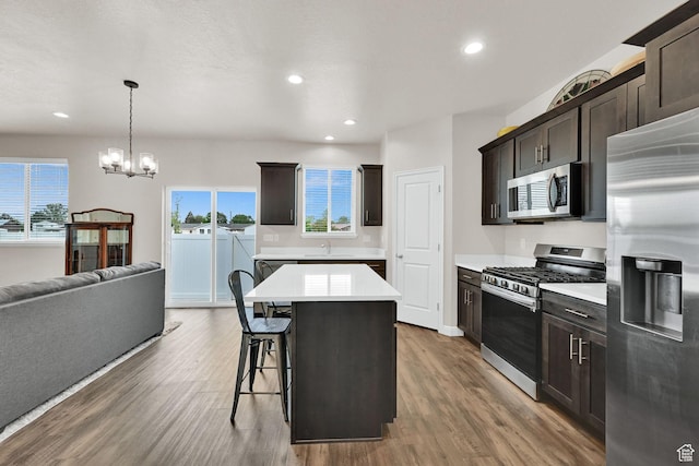 250 W 1200 S Unit 127, Tremonton, UT 84337 - kitchen featuring appliances with stainless steel finishes, light countertops, wood finished floors, a chandelier, and a breakfast bar area