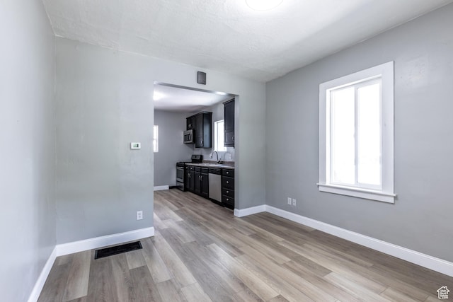 2665 S 8900 W, Magna, UT 84044 - unfurnished living room featuring light wood finished floors, a sink, and baseboards