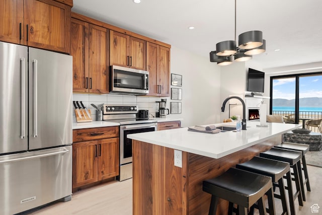 35 E 150 S Unit 202C, Garden City, UT 84028 - kitchen featuring appliances with stainless steel finishes, brown cabinetry, open floor plan, light countertops, and a sink