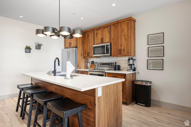 35 E 150 S Unit 202C, Garden City, UT 84028 - kitchen featuring appliances with stainless steel finishes, brown cabinets, light wood finished floors, and recessed lighting