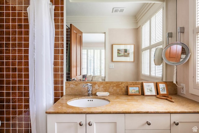 bathroom with healthy amount of natural light, crown molding, vanity, and a shower with curtain