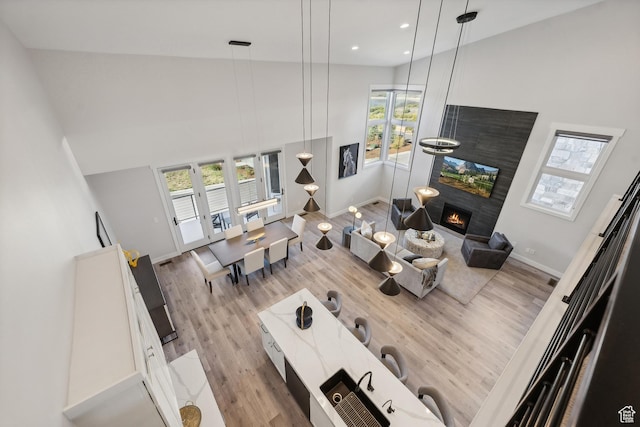 363 E Overlook Loop E Unit 22, Hideout, UT 84036 - living area featuring wood finished floors, baseboards, a warm lit fireplace, a high ceiling, and recessed lighting