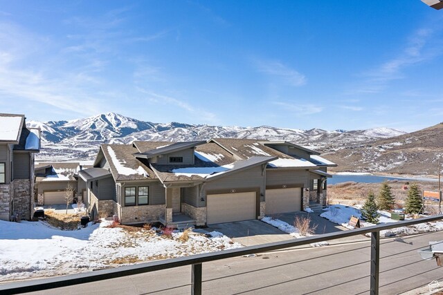 363 E Overlook Loop E Unit 22, Hideout, UT 84036 - view of front of home featuring a mountain view, a garage, stone siding, and driveway