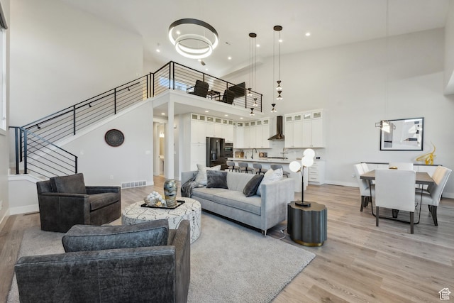 363 E Overlook Loop E Unit 22, Hideout, UT 84036 - living area featuring light wood-style flooring, stairway, a high ceiling, baseboards, and recessed lighting
