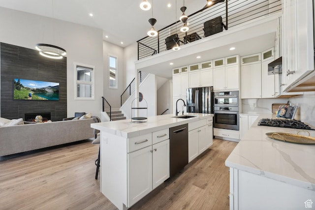 363 E Overlook Loop E Unit 22, Hideout, UT 84036 - kitchen featuring dishwashing machine, a sink, light stone counters, white cabinetry, and light wood-style floors