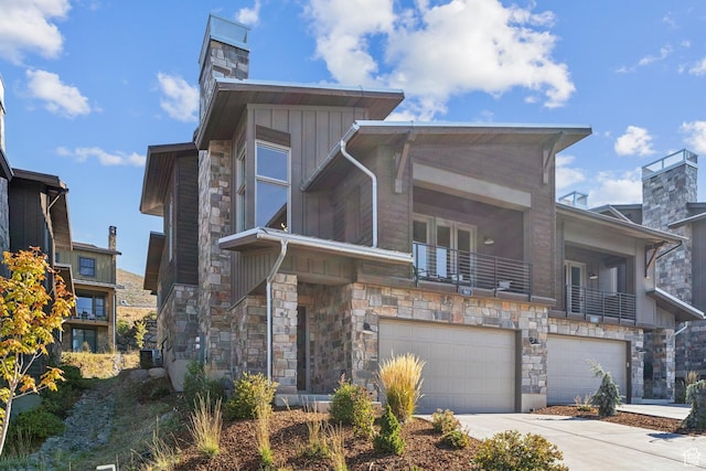 363 E Overlook Loop E Unit 22, Hideout, UT 84036 - contemporary home with stone siding, an attached garage, a chimney, and concrete driveway