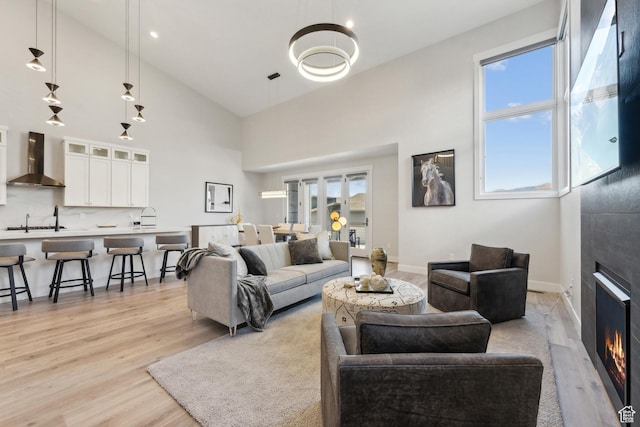 363 E Overlook Loop E Unit 22, Hideout, UT 84036 - living room featuring light wood-type flooring, a large fireplace, high vaulted ceiling, and baseboards