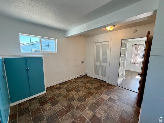 unfurnished room featuring a textured ceiling, baseboards, and a smoke detector